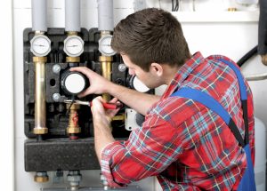 Technician servicing heating boiler