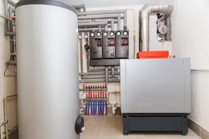 A domestic household boiler room with a new modern heating oil warm water system and pipes